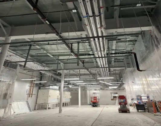 Cold storage area interior with insulation, pipes, and lights.