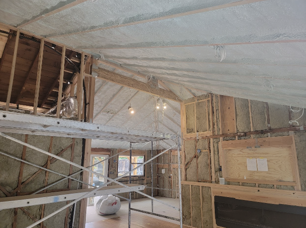  Interior view of a large custom home under construction with spray foam insulation applied to the roof and walls.

              