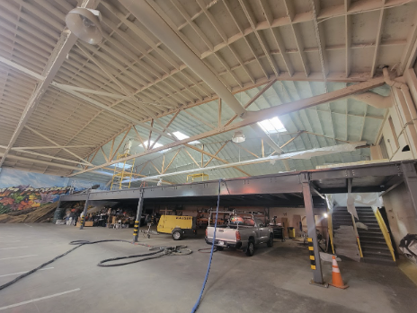  Interior view of a large commercial building with spray foam insulation being applied to the ceiling by USA Spray Me.

              