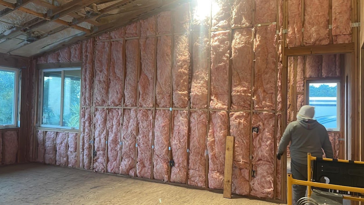     Fiberglass insulation being installed in a residential property.