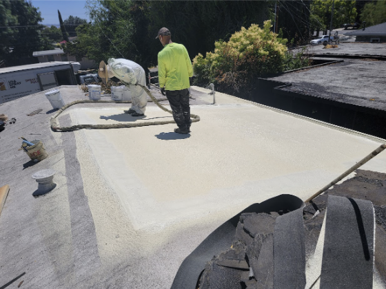  

                     Workers applying spray foam insulation on a rooftop.

                     