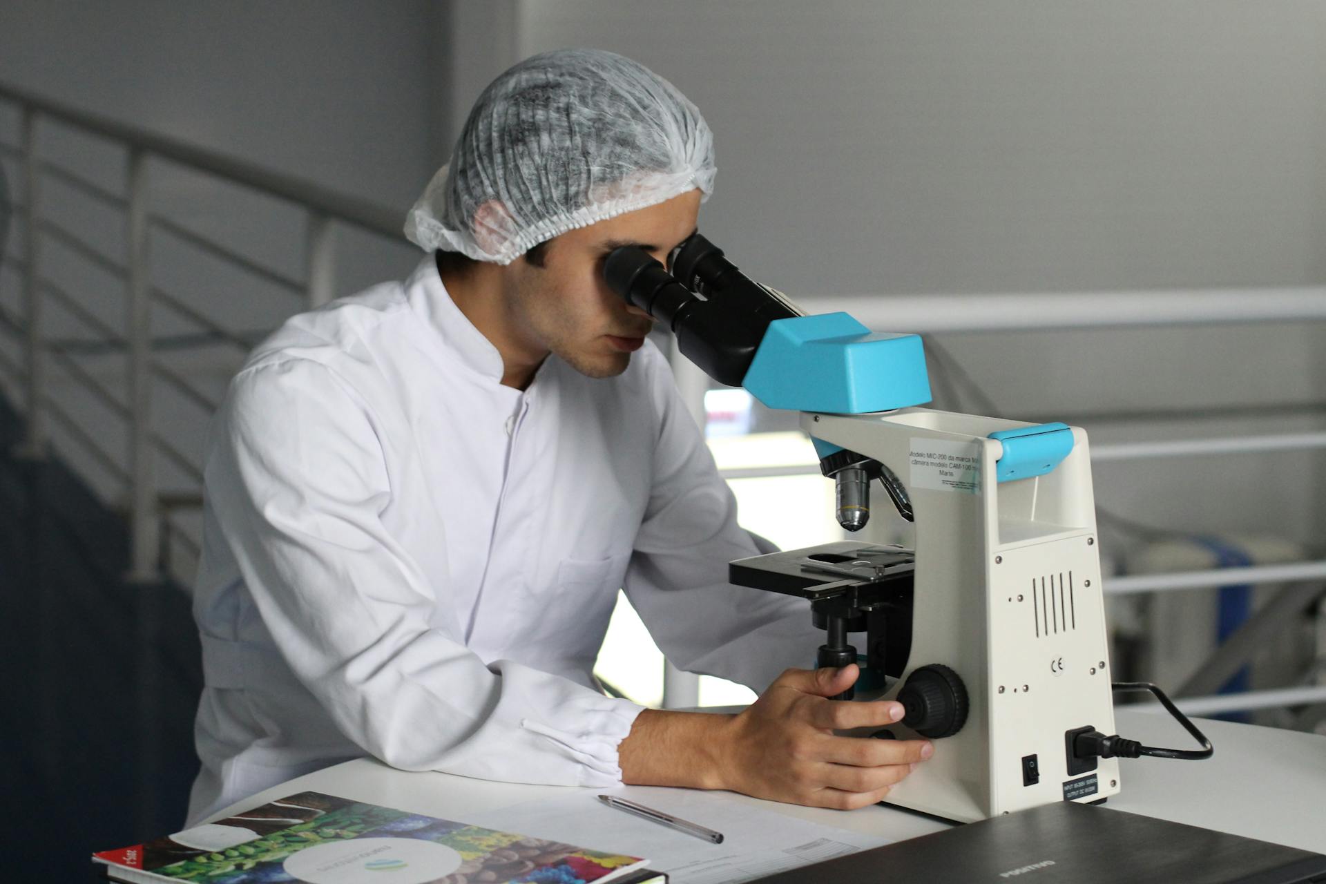  

                     A research lab assistant looking through a microscope.


                     