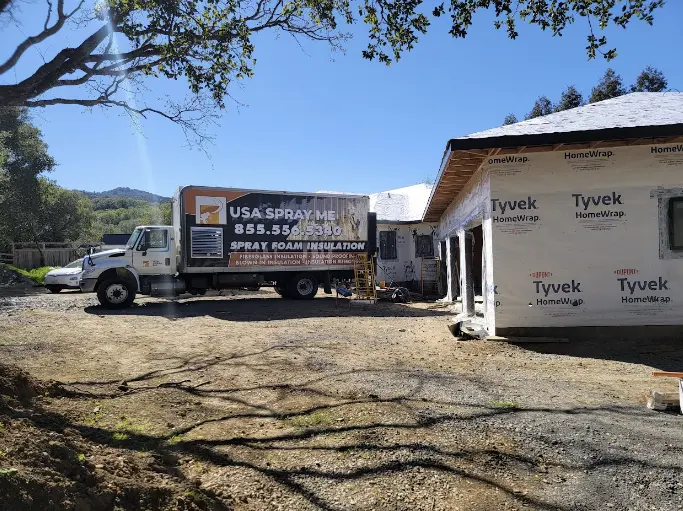 USA Spray Me truck at a residential construction site, demonstrating their versatility in providing insulation services for various types of buildings.