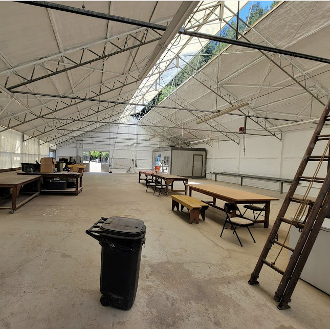  
         
         Interior view of an insulated agricultural structure with tables and equipment.


         