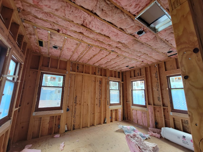  


                     Fiberglass insulation installed between wooden framing inside a house.




                     