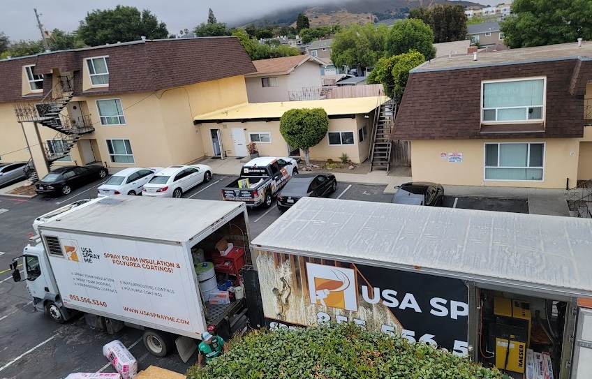  

                  USA Spray Me trucks parked outside a residential complex.





                  