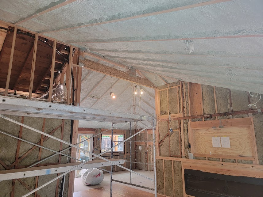  


                     Spray foam insulation applied under a roof with a skylight, overlooking a city skyline.





                     