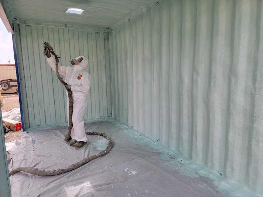  


                     Technician applying spray foam insulation inside a container.





                     