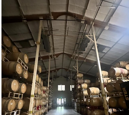  
               Wine cellar with barrels stacked and spray foam insulation on the ceiling.



      
      
      
               