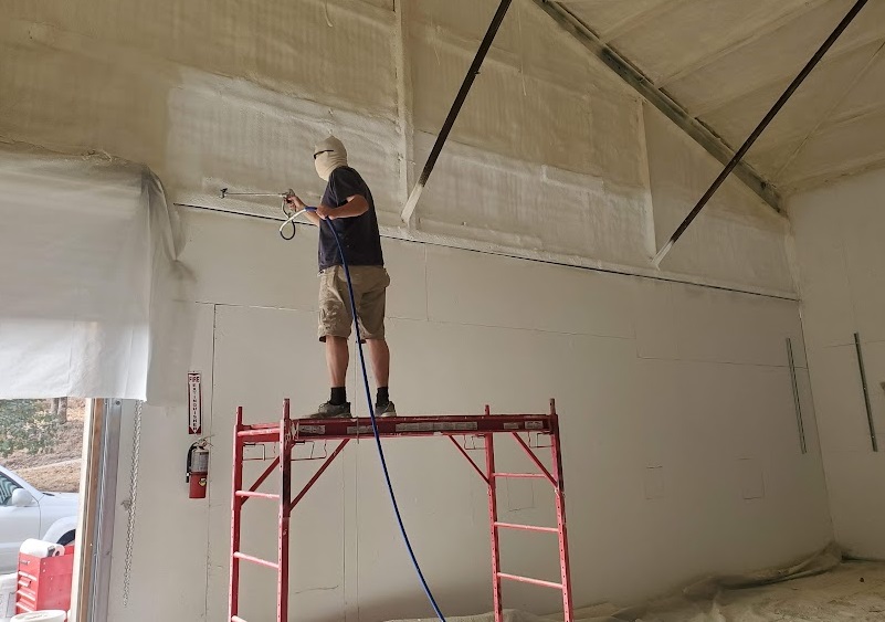  


                     Technician applying spray foam insulation to walls inside a research lab.




                     