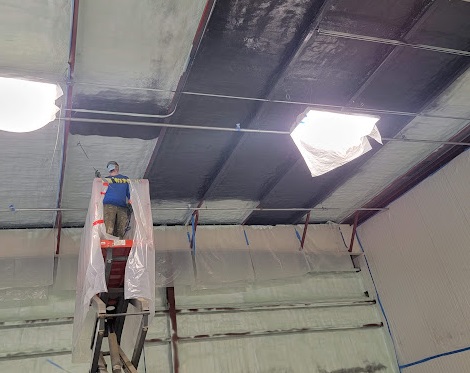  

                  Technicians installing commercial insulation in a large open space.






                  