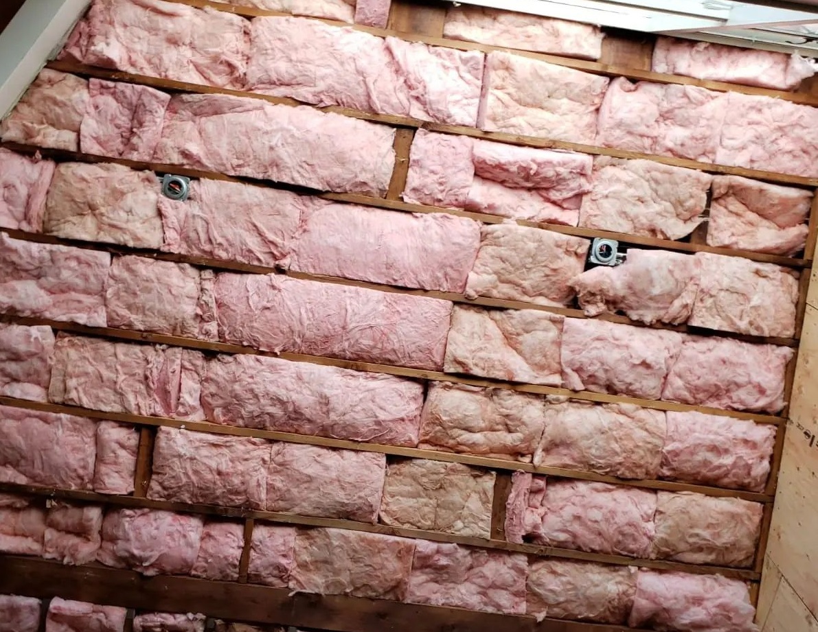  
               
               

               Pink fiberglass insulation installed in wall cavities for a building.

      
      
      
               