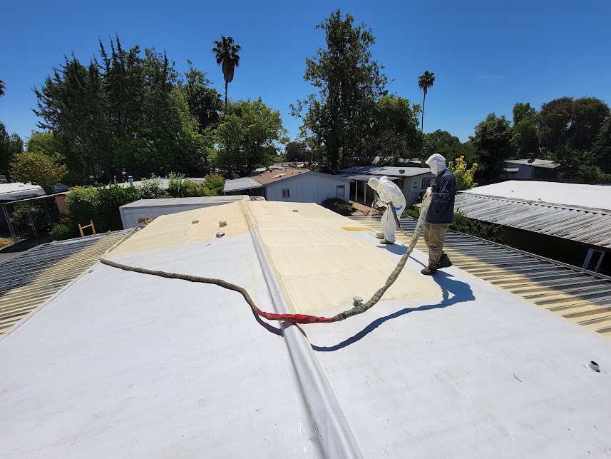  

                     Workers applying spray foam insulation on a residential roof under clear skies.






                     