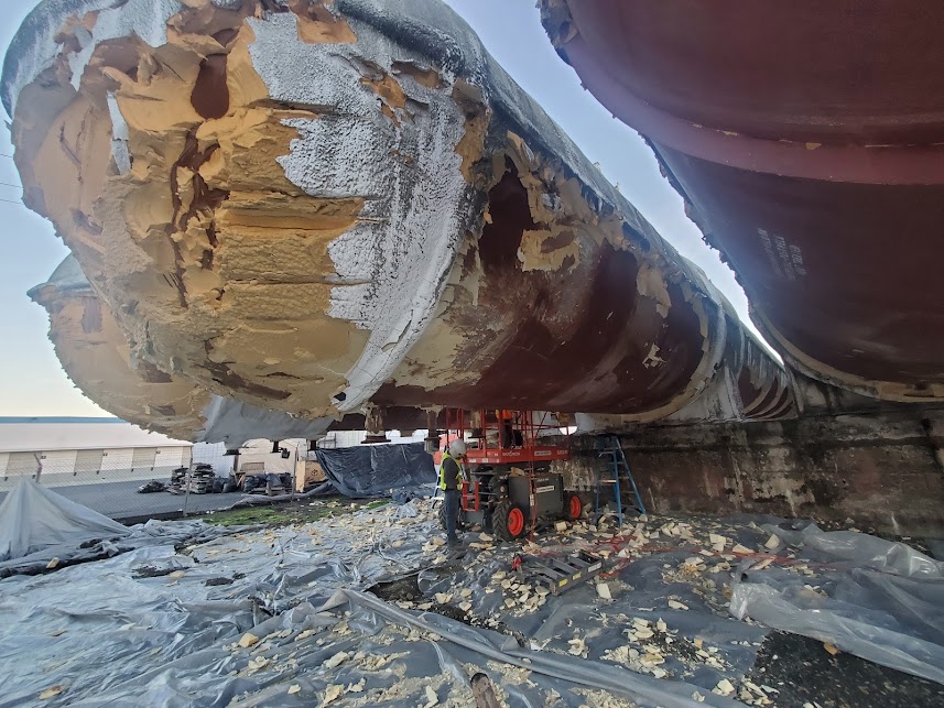  

                     Workers stripping and preparing the base of cold storage tanks.




                     