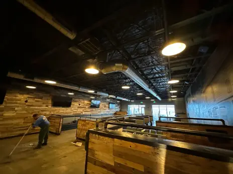 An employee cleans the floor of a restaurant under renovation