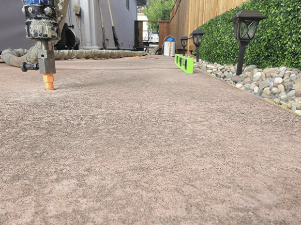 Close-up of polyurethane foam injection into a concrete driveway during insulation and leveling work in San Jose.
