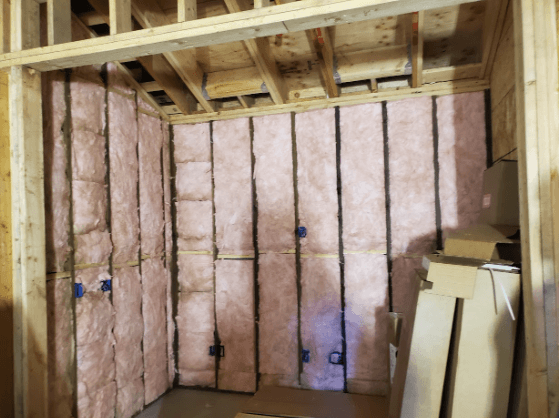Interior view of a wine cellar with spray foam insulation applied to walls and ceiling.