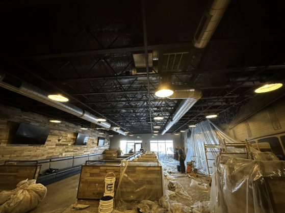 Interior view of a meat processing plant under construction with spray foam insulation on the ceiling.