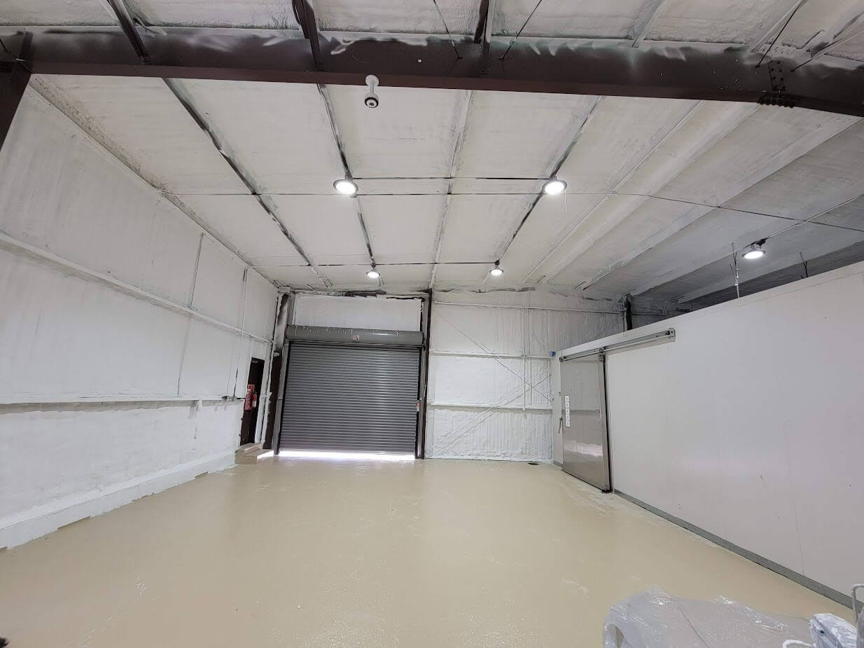 The interior of a recycling center with spray foam insulation on the walls and ceiling.