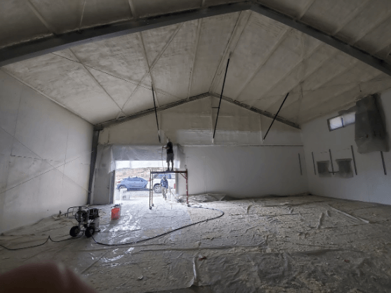 Spray foam insulation being applied to the ceiling of a commercial building in San Jose to enhance energy efficiency.