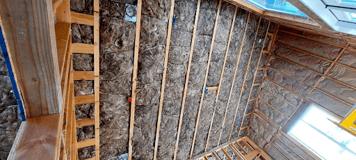 Custom home under construction in Oakland featuring spray foam insulation on the ceiling for optimal thermal resistance and energy savings.