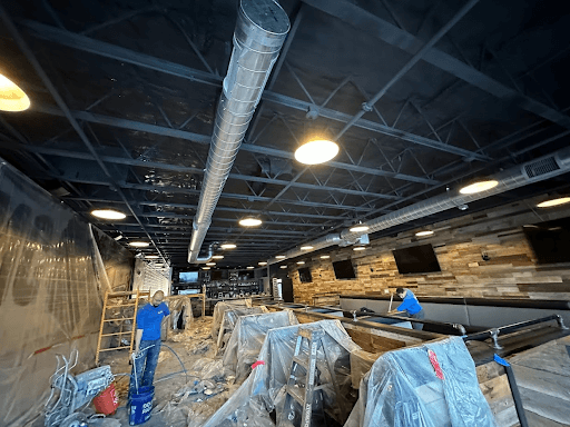 Contractors applying spray foam insulation in a Napa Valley commercial space.