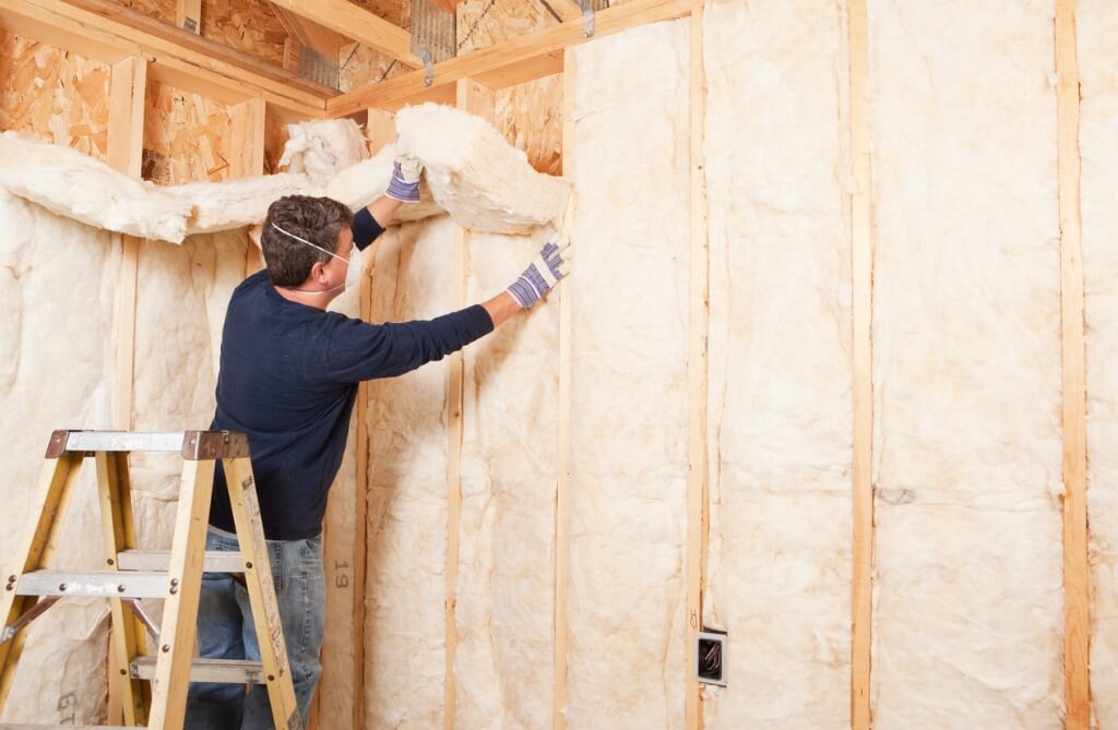 Installing fiberglass wall insulation for a commercial space.