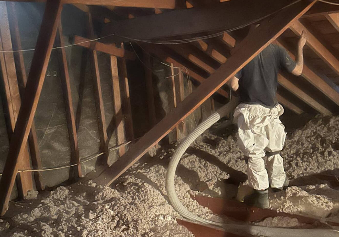  USA Spray Me contractor applying blown-in insulation to an attic space 