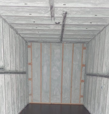 Interior of a room with spray foam insulation applied to the walls and ceiling.