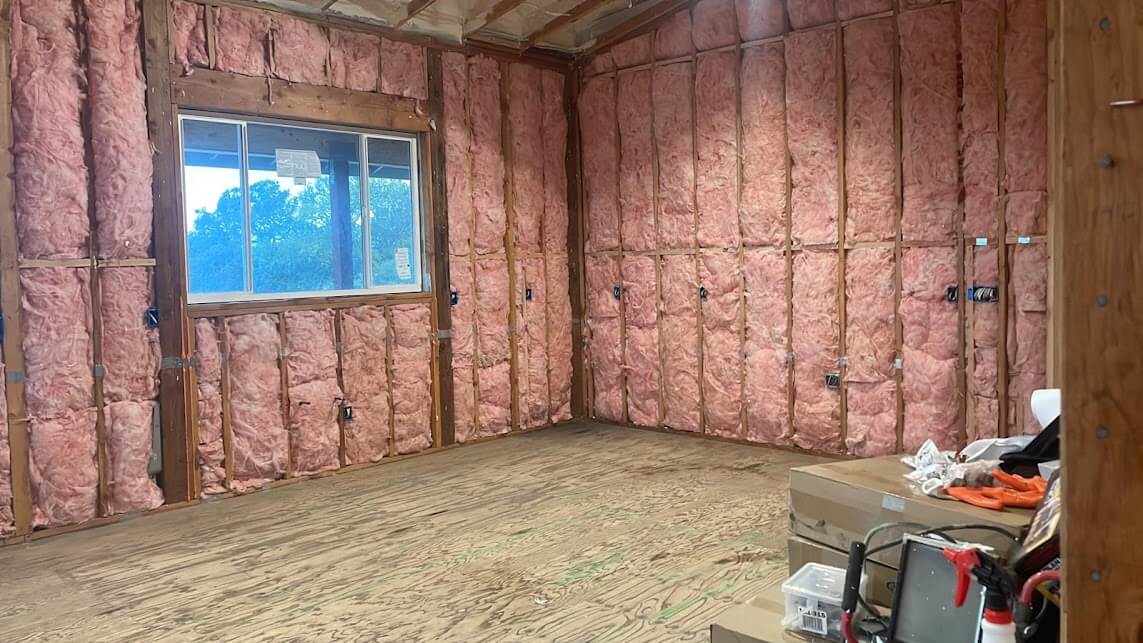  Room walls insulated with fiberglass, prepared for interior finishing. 