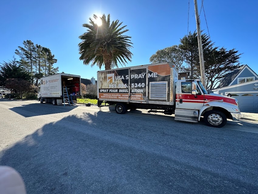 USA Spray Me truck and vehicle parked in front of a building.