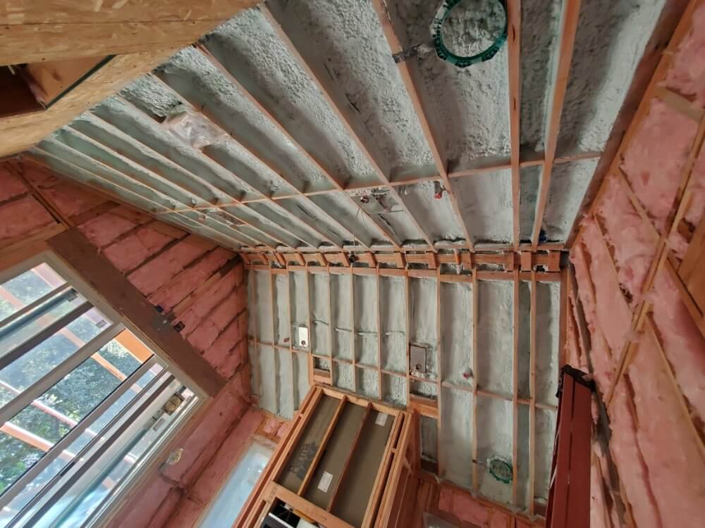 Ceiling with both spray foam insulation and batt insulation in an unfinished room. 