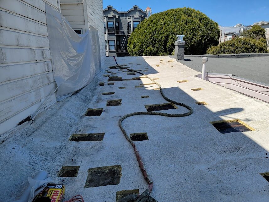  A prepared low-slope roof with sections cut for spray polyurethane foam insulation installation. 