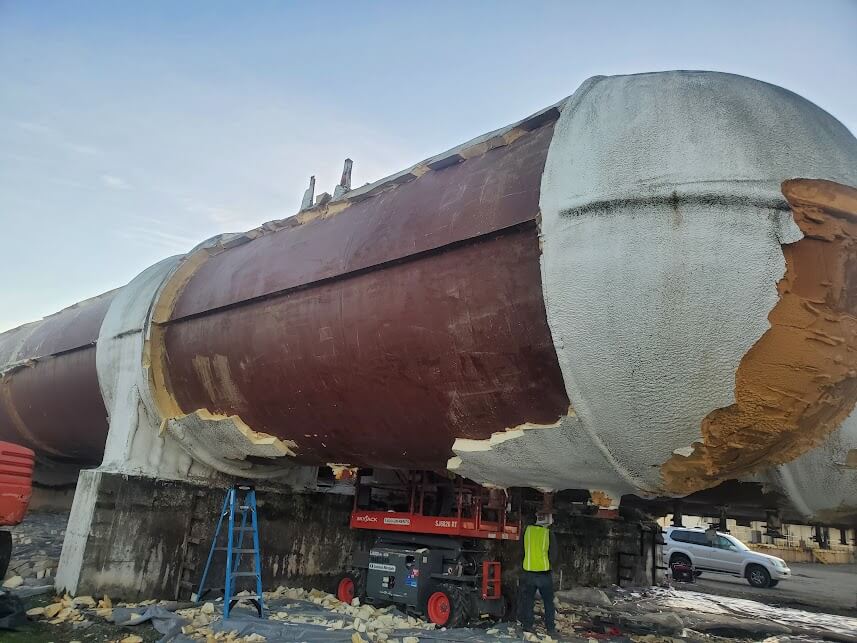 A close-up of a partially stripped cold storage tank being prepared for SPF insulation.